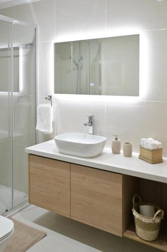 a white bathroom with a sink and a shower at Oikou Thea Guesthouse in Oikos