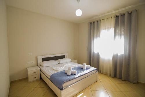 a bedroom with a bed with two towels on it at Harris&Arvien Apartment's in Vlorë