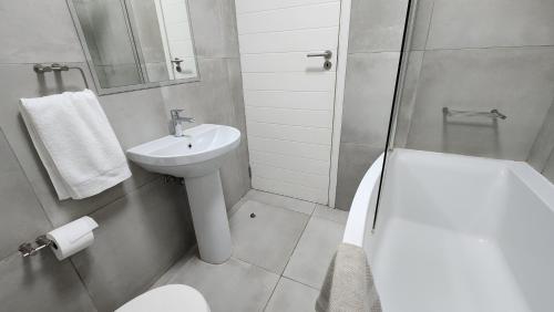 a bathroom with a sink and a toilet and a shower at Marina View in Velddrif