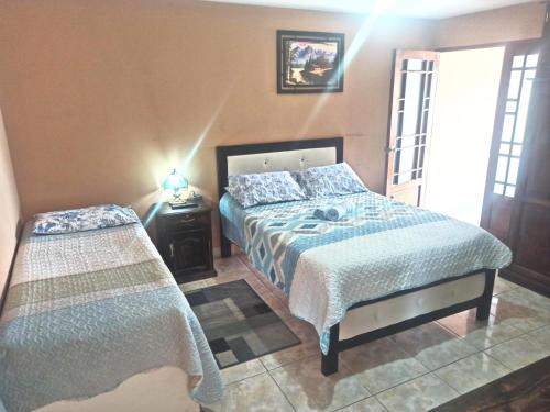 ein Schlafzimmer mit einem Bett und einem Nachttisch mit einem Bett von sidx sidx sidx sidx sidx in der Unterkunft Residencial Moroni - Alojamiento en Cochabamba in Cochabamba