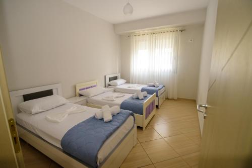 a room with three beds and a window at Harris&Arvien Apartment's in Vlorë