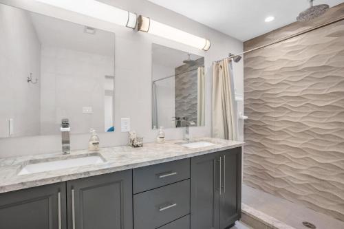 a bathroom with two sinks and a large mirror at Salt Water Heated Pool Home with a Tiki Bar, a Garage Game Room and 4 Bikes in Naples