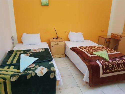 two beds sitting next to each other in a room at Luxor family in Luxor