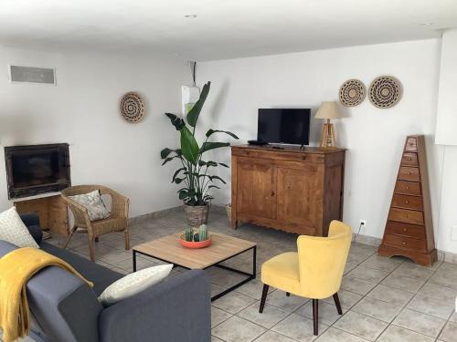 a living room with a couch and a tv at Le petit Four Neuf in Lézardrieux