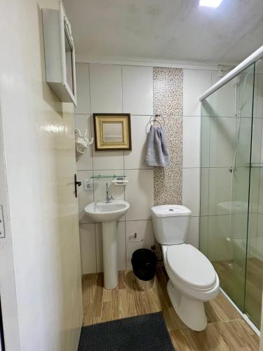 a bathroom with a toilet and a sink at Pôr-do-Sol Pousada in Penha