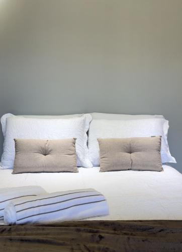 een wit bed met twee kussens erop bij Chalés Peterli 2 in Venda Nova do Imigrante