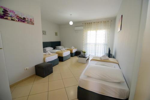 a room with four beds and a window at Harris&Arvien Apartment's in Vlorë