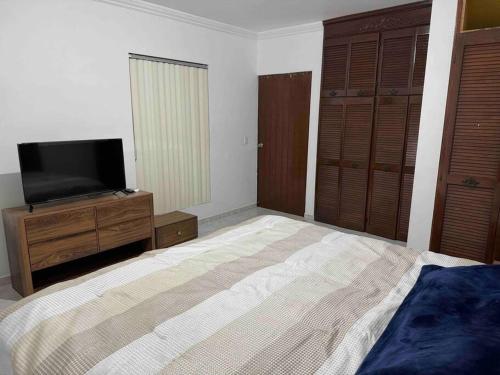 a bedroom with a bed and a flat screen tv at Amplia residencia en Ciudad Obregón in Ciudad Obregón
