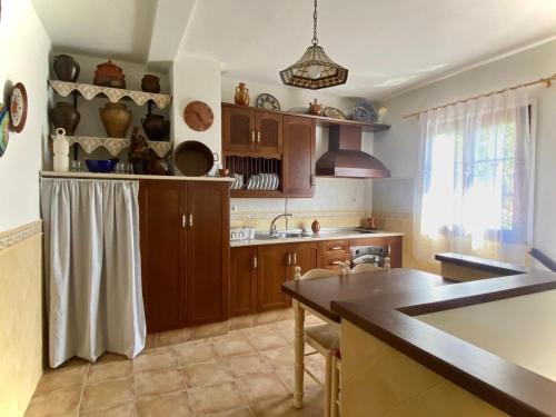 a kitchen with wooden cabinets and a counter top at Villa Nadimar - Casa rural con terraza magnífica y 4 habitaciones in Benecid