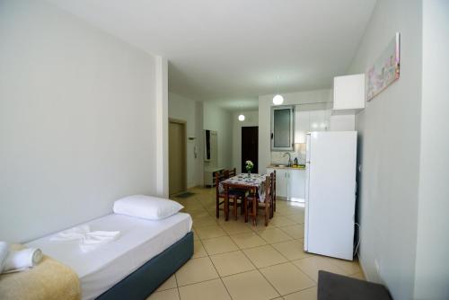 a room with a bed and a kitchen with a table at Harris&Arvien Apartment's in Vlorë