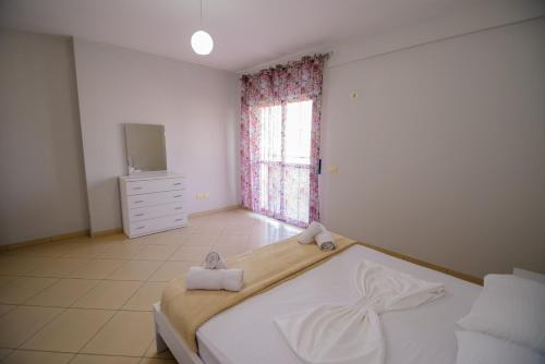 a bedroom with a bed with two towels on it at Harris&Arvien Apartment's in Vlorë