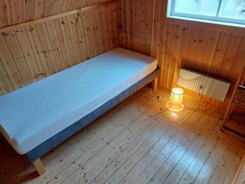 a small room with a bed and a light on the floor at Elanden rust in Edebäck