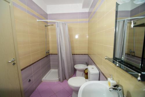 a bathroom with a toilet and a shower and a sink at Harris&Arvien Apartment's in Vlorë