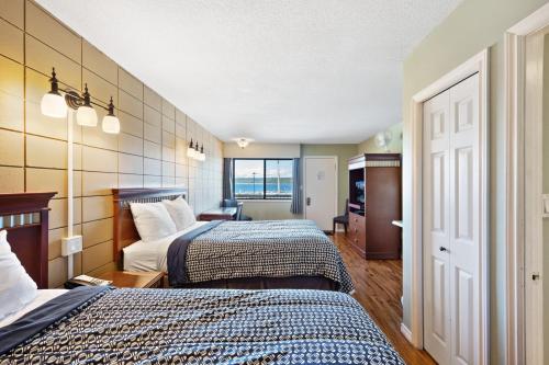 Habitación de hotel con 2 camas y ventana en Big Rock Motel en Campbell River