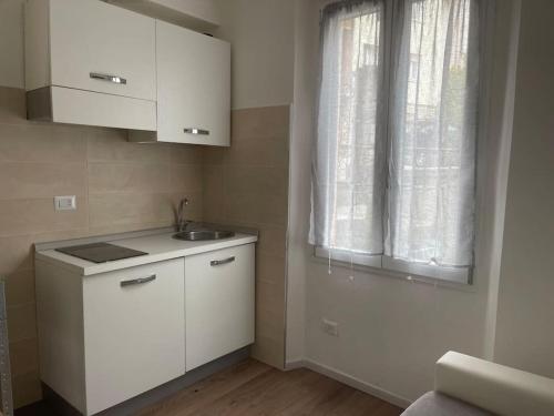 a small kitchen with a sink and a window at l'ETRANGE RENDEZ-VOUS TOME 1&2 in Carona