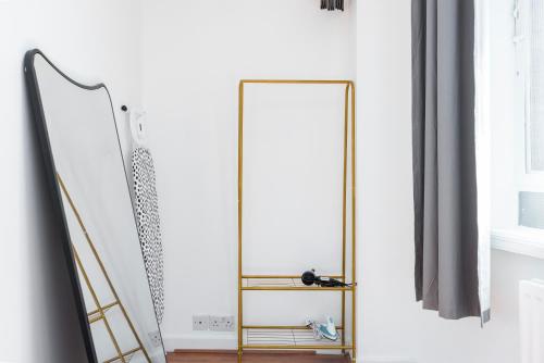 einen goldenen Spiegel in einem Bad neben einer Leiter in der Unterkunft Spacious 1 BR Near London Bridge - 5 Min Walk in London