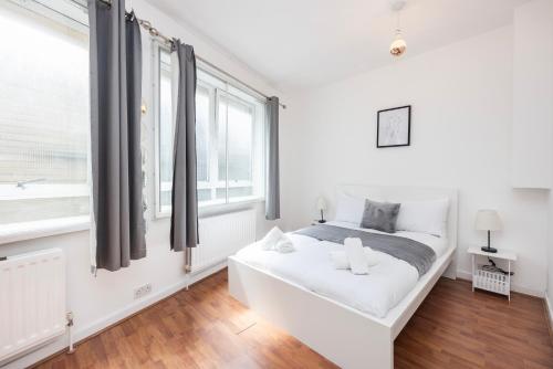 ein weißes Schlafzimmer mit einem Bett und einem Fenster in der Unterkunft Spacious 1 BR Near London Bridge - 5 Min Walk in London