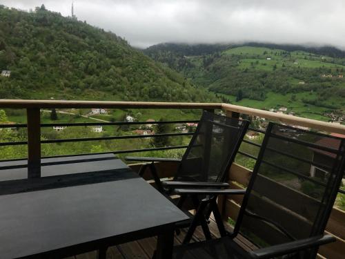 een tafel en stoelen op een balkon met uitzicht op een berg bij Superbe appartement neuf avec Sauna privé & Terrasse vue sur la montagne in La Bresse