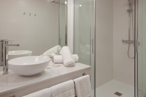 uma casa de banho com um lavatório e uma cabina de duche em vidro. em Hotel Jucamar em Cangas