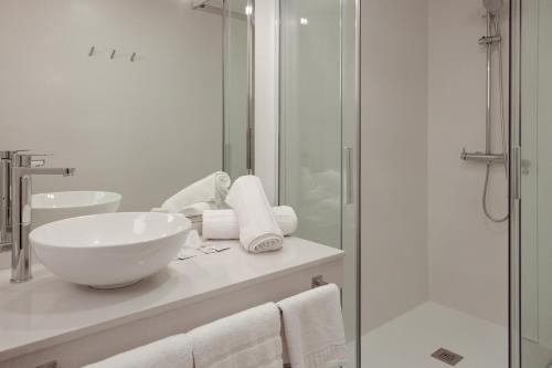 a bathroom with a sink and a glass shower at Hotel Jucamar in Cangas de Morrazo