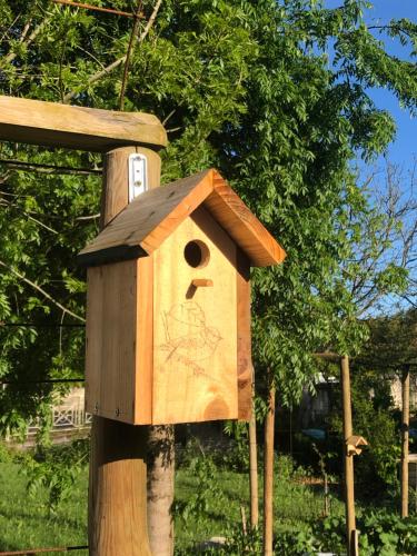 a wooden bird house on a wooden pole at Chambre d’hôtes in La Brousse