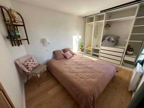 une chambre avec un lit et une chaise dedans dans l'établissement Charmant appartement 15 min de Lille, à Marcq-en-Barœul