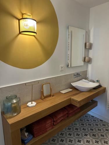 une salle de bain avec un lavabo et un miroir dans l'établissement Charmant appartement 15 min de Lille, à Marcq-en-Barœul