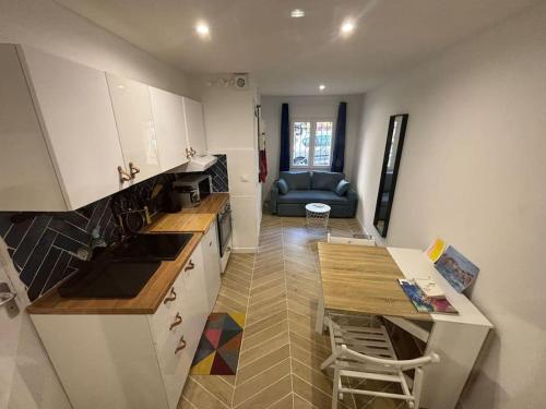 une cuisine avec des armoires blanches, une table et un canapé dans l'établissement Appartement 2P au Panier, à Marseille