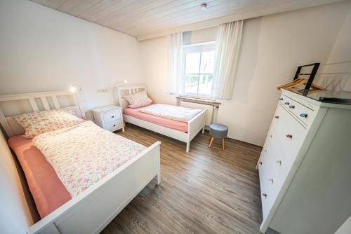 Aicha vorm WaldにあるSchöne Ferienwohnung vor den Toren Pullman Citysの小さなベッドルーム(ベッド2台、ドレッサー付)