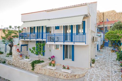 a house with blue balconies and flowers on a street at Pythagoreio Blue Street Apartment with Terrace in Pythagoreio