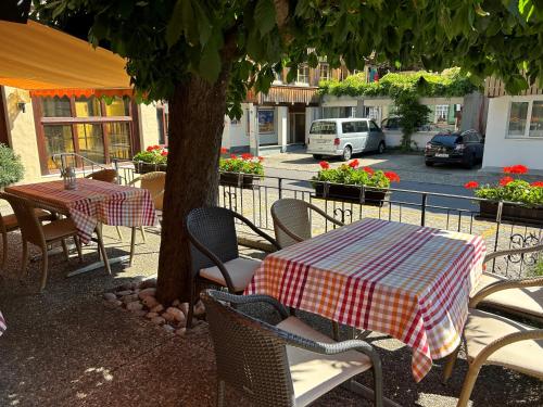 a table and chairs with a table and a tree at Baeren Hotel, The Bear Inn in Wilderswil