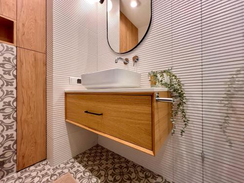 een badkamer met een wastafel en een spiegel bij Clima Apartment III in Wrocław