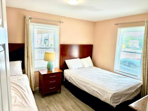 a small bedroom with two beds and two windows at Bill's Apartments in Ocean City