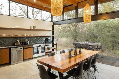 a kitchen and dining room with a table and chairs at Rixile Kruger Lodge in Skukuza