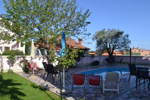 einen Garten mit Stühlen und einem Pool in der Unterkunft Villa Baldi -Apartmani Danny in Tar