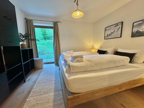 Un dormitorio con una cama grande y una ventana en Ferienhaus "Bodenschneid" am Schliersee en Schliersee