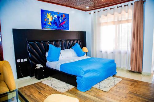 a bedroom with a large bed with a blue comforter at NETLUNA VILLA HOTEL in Kigali
