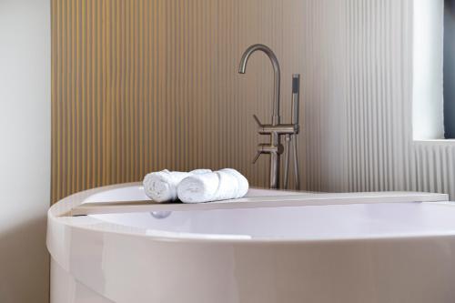 马尼萨莱斯Nodo Hotel的浴室配有浴缸和毛巾。
