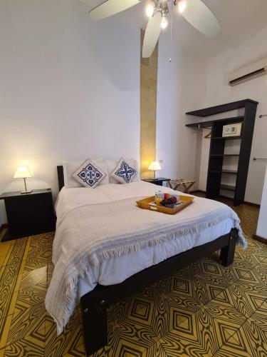 a bedroom with a bed with a tray of food on it at Posada El Capullo in Colonia del Sacramento