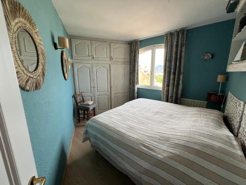 - une chambre avec un lit aux murs bleus et un miroir dans l'établissement Belle vue Golfe de St Tropez Marines de Cogolin La Galiote, à Cogolin