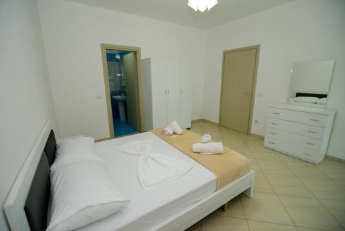 a bedroom with a bed with towels on it at Harris&Arvien Apartment's in Vlorë
