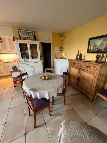 une cuisine avec une table et des chaises dans une pièce dans l'établissement Belle vue Golfe de St Tropez Marines de Cogolin La Galiote, à Cogolin