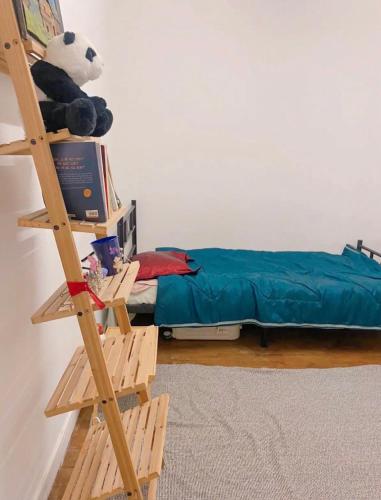 une échelle dans une pièce avec un lit et un ours en peluche dans l'établissement Small room next to train B easily go to centre ville, à Cachan