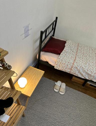 - une chambre avec un lit, une table et des chaussons dans l'établissement Small room next to train B easily go to centre ville, à Cachan