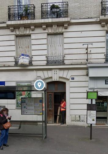 un bâtiment avec une enseigne devant lui dans l'établissement Small room next to train B easily go to centre ville, à Cachan