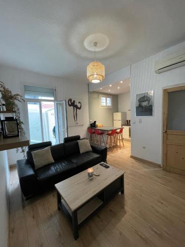- un salon avec un canapé noir et une table dans l'établissement Cosy nid douillet au cœur du centre ville de Perpignan, à Perpignan