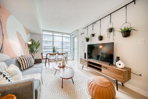 a living room with a couch and a tv at Stylish Downtown Toronto Suite with Free Parking in Toronto