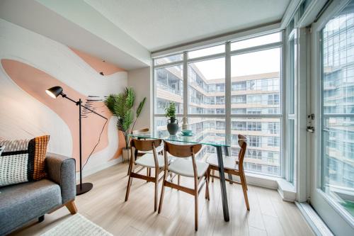a dining room with a glass table and chairs at Stylish Downtown Toronto Suite with Free Parking in Toronto
