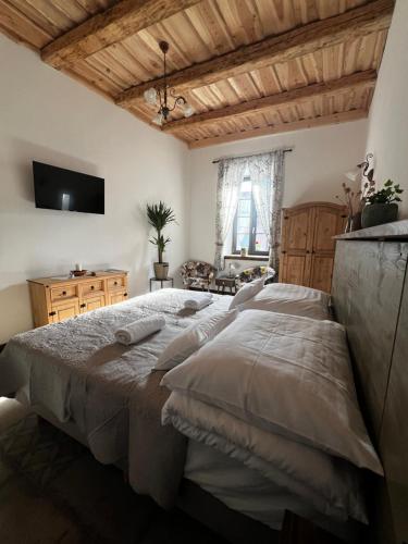 a bedroom with a large bed and a television at Zöldkapu Vendégház in Balassagyarmat