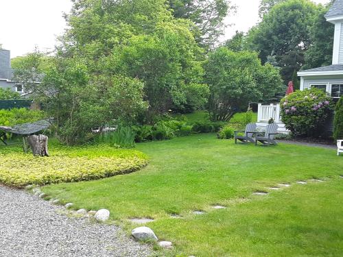 a yard with a bench and a garden with grass at Bourne Bed and Breakfast in Ogunquit